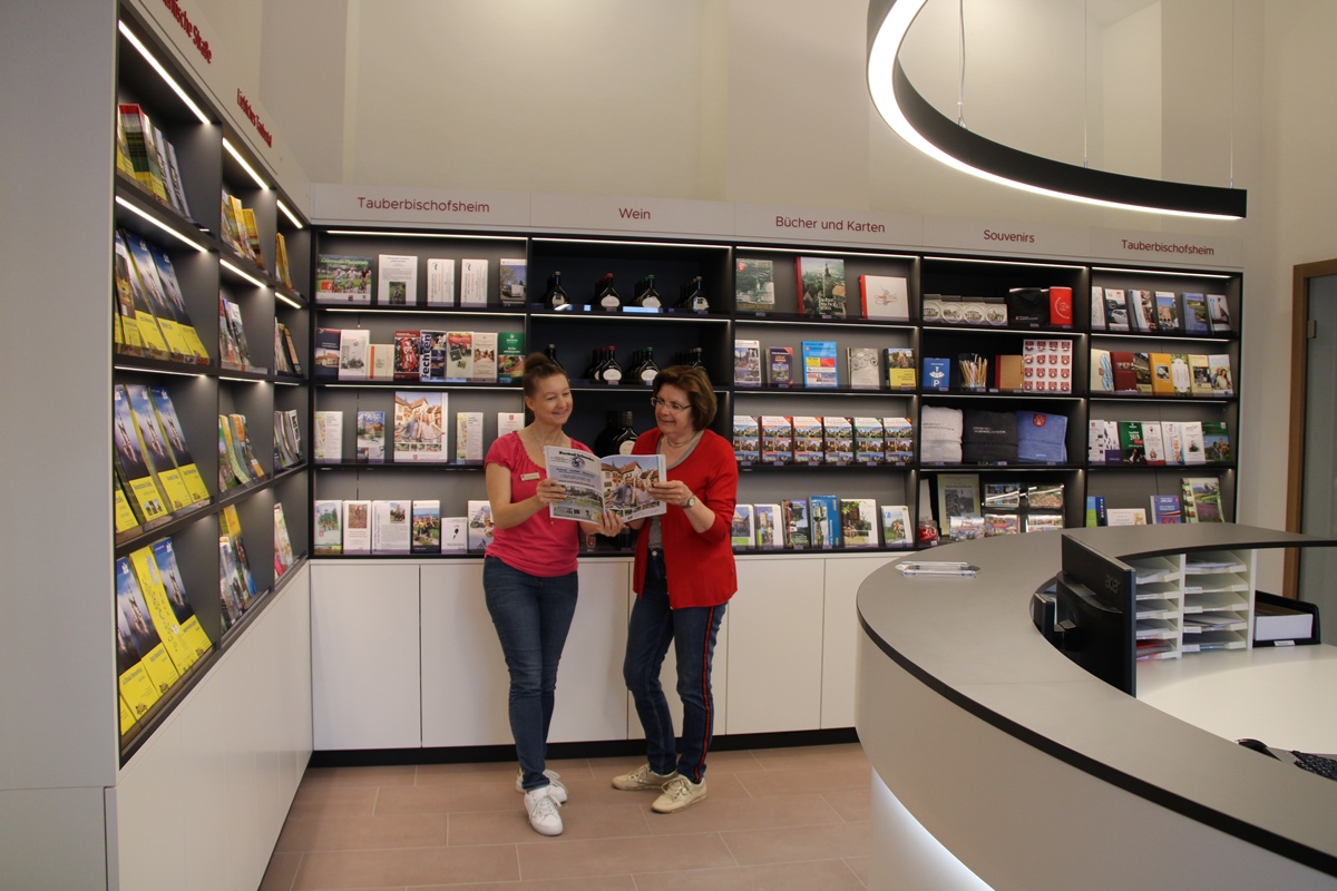 Tourist-Information Tauberbischofsheim von innen. Mitarbeiterin der Tourist-Information Tauberbischofsheim hilft Gästen weiter.